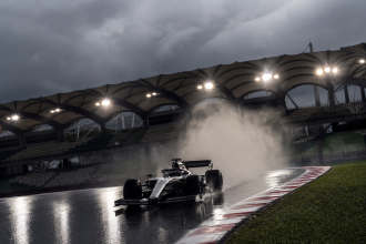 Carro de Fórmula 1 de Max Verstappen em pista molhada no circuito de Sepang durante o GP do Bahrein de 2026