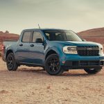 Picape Ford Maverick azul estacionada em uma paisagem desértica.