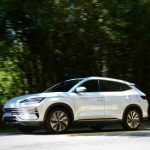 SUV branco trafega por uma estrada cercada por vegetação, em Monteiro Lobato (SP).