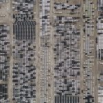 Vista aérea de um amplo pátio no Brasil com milhares de veículos estacionados.