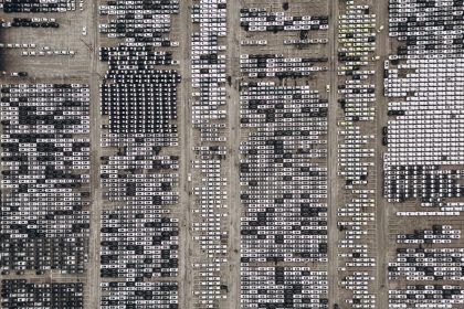 Vista aérea de um amplo pátio no Brasil com milhares de veículos estacionados.