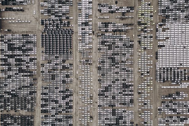 Vista aérea de um amplo pátio no Brasil com milhares de veículos estacionados.