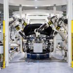 Robôs industriais montam um automóvel em uma fábrica automotiva moderna.