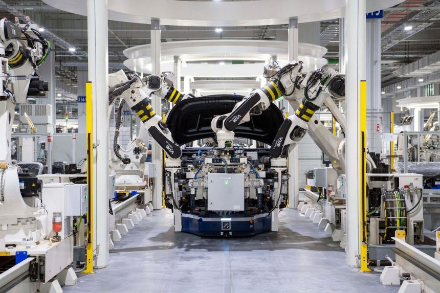 Robôs industriais montam um automóvel em uma fábrica automotiva moderna.